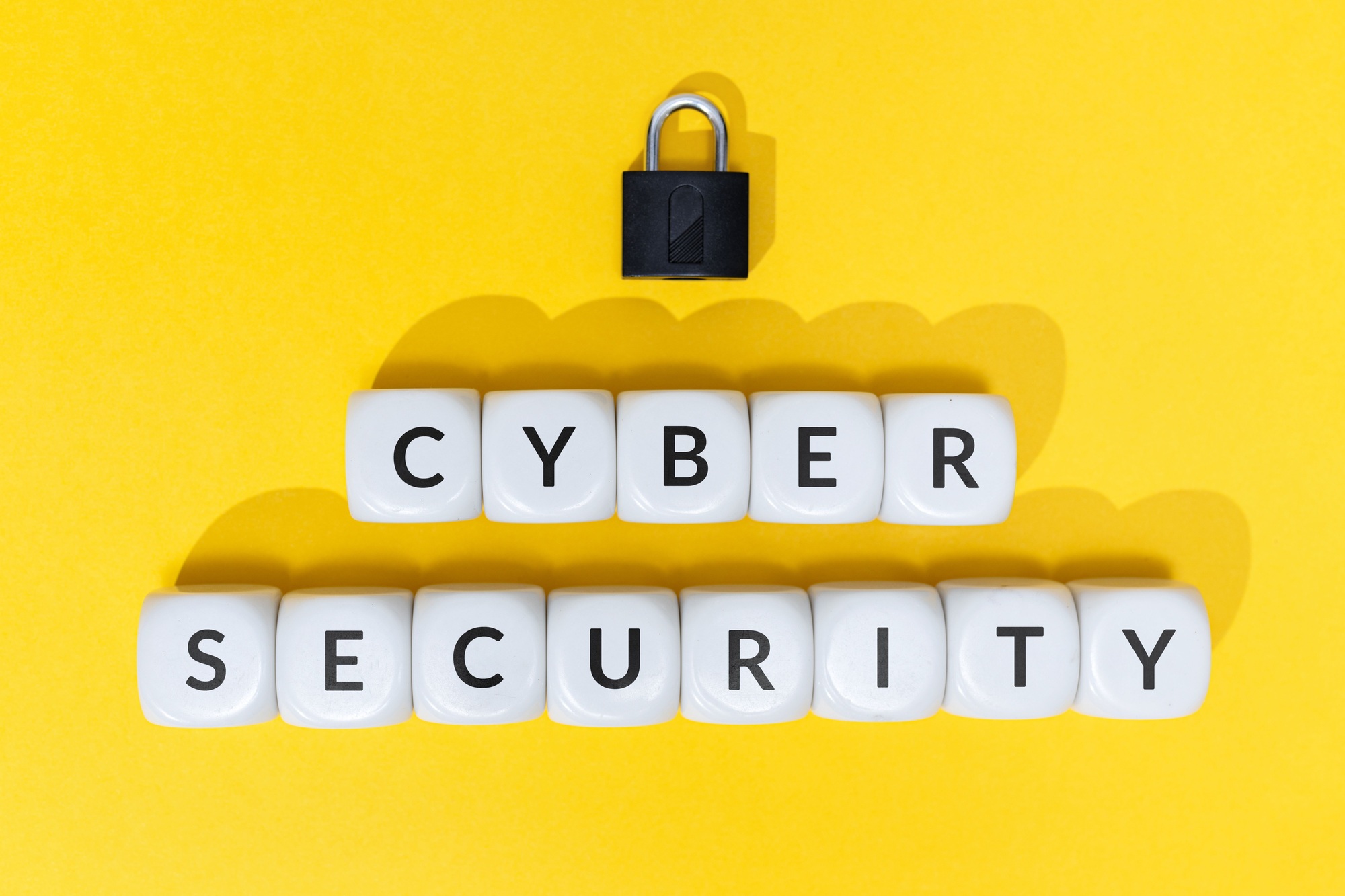 Cyber security Text on blocks and padlock on yellow background